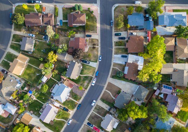 The bird's eye view of a suburban neighborhood in denton is pictured, with single family homes lined with residential roads and lawns.