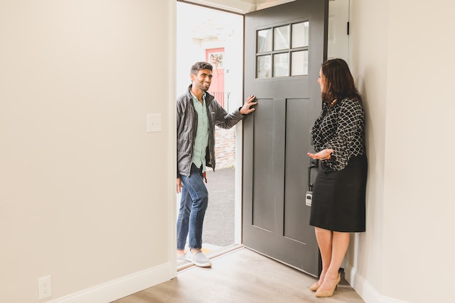 real estate agent welcoming possible tenant into empty home